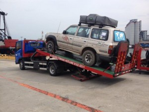 Cars being taken from container and placed on tow trucks in Singapore & trucked to Malaysian border 6 