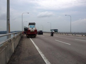 Cars being unloaded in the middle of bridge on boarder between Singapore and Malaysia 